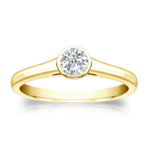 Round-cut diamond solitaire engagement ring with a touch of Yaffie Gold and 1/4ct total diamond weight, set perfectly in a sleek bezel design.