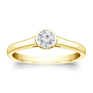 Round-cut diamond solitaire engagement ring with a touch of Yaffie Gold and 1/4ct total diamond weight, set perfectly in a sleek bezel design.